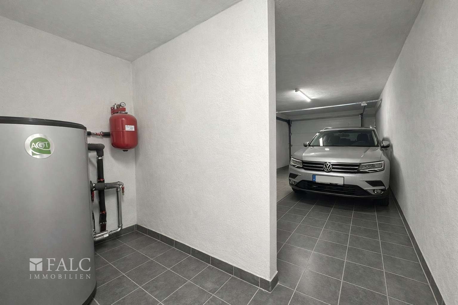 „Garage mit separatem Heizungsraum, aktuell baubedingt mit Material belegt – Visualisierung.“